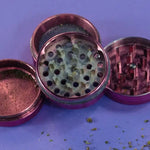 Gebräuchlicher metallisch-pink Grinder mit Sieb und Zähnen aus dem Grinder Guide