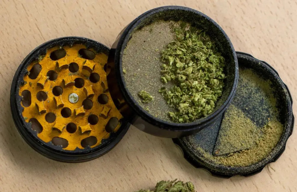 4-teiliger Aluminium-Grinder schwarz-gelb mit Pollenfach und grünem Cannabis.