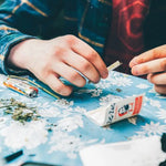 Weiß-rotes Marihuana-Päckchen geöffnet – wichtiger Schritt beim Joint drehen